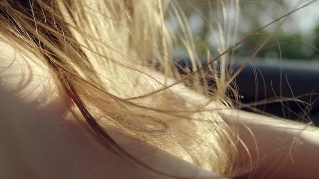 近距离女人的头发在风中吹，而坐在敞篷车。近距离视频素材