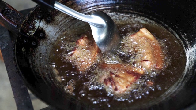 高清慢镜头广角拍摄在厨房的煎锅里煎五花肉。用滚油炸猪肉。视频下载