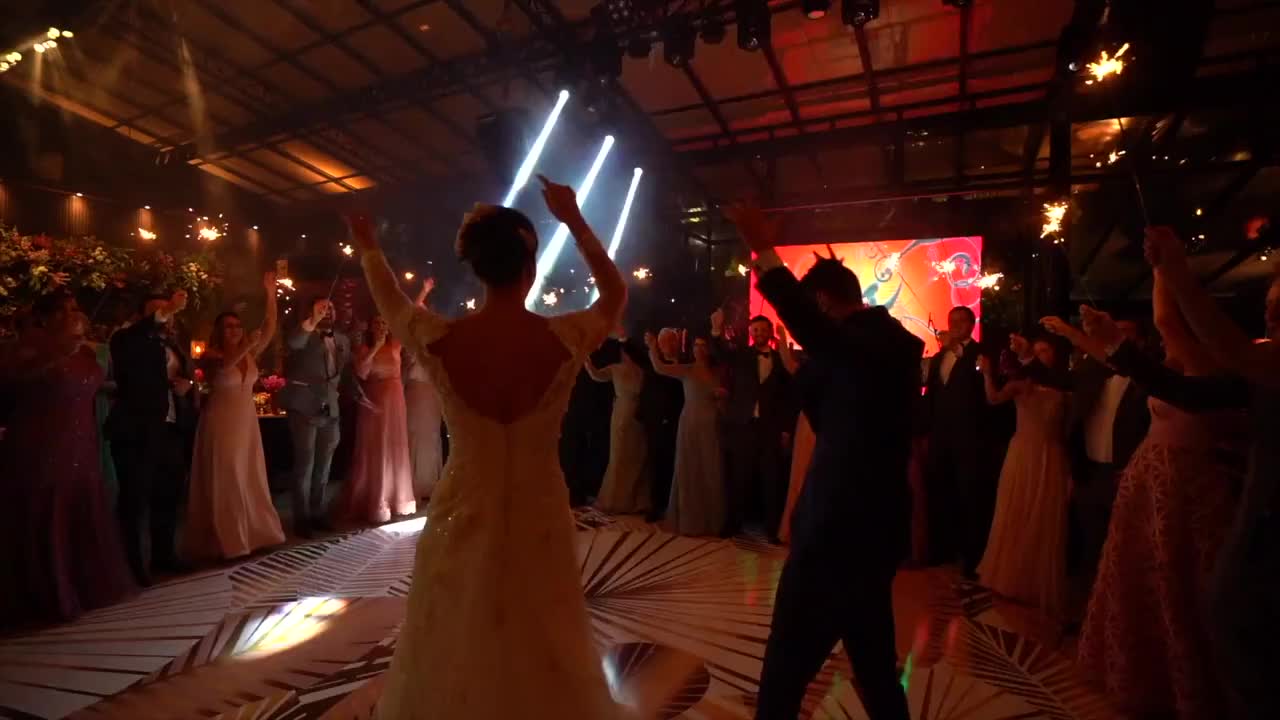 新婚夫妇跳舞，婚礼宾客拿着烟花视频素材