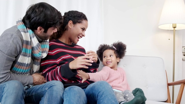 幸福白种人和拉丁家庭在沙发客厅背景上一起嬉戏快乐视频素材