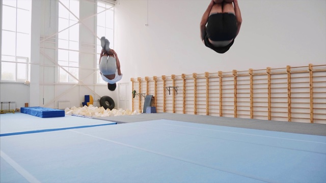 两个运动员做一个侧手翻和两个后空翻，稳定器，慢动作。视频下载