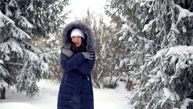 一位年轻女子正走在一片美丽的冬季森林里视频下载