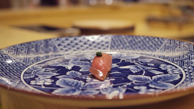 日式omagase餐厅的厨师用筷子烹饪，并把鱼腥酱金枪鱼生鱼片放在日式料理中。视频素材