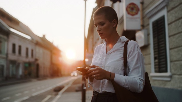 黄昏时分在城市里使用智能手机的现代商务女性视频素材