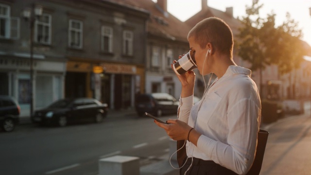 现代商业女性在城市的人行道上使用智能手机视频素材