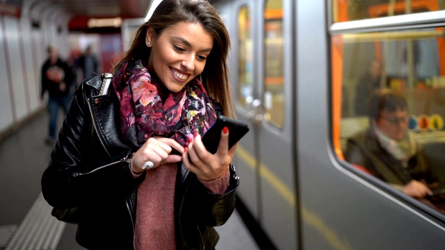 在地铁站使用手机的女性通勤者视频素材