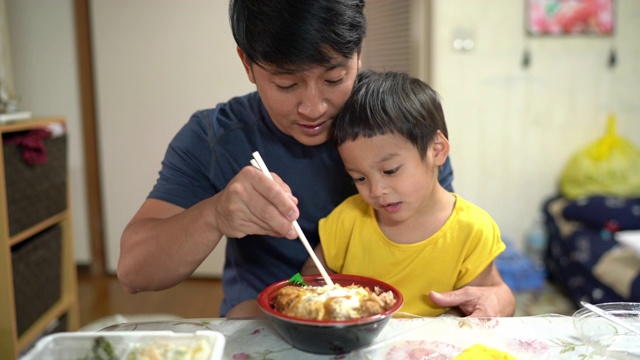 快乐的父子俩，小男孩喜欢在家吃日本猪排饭，2岁视频下载