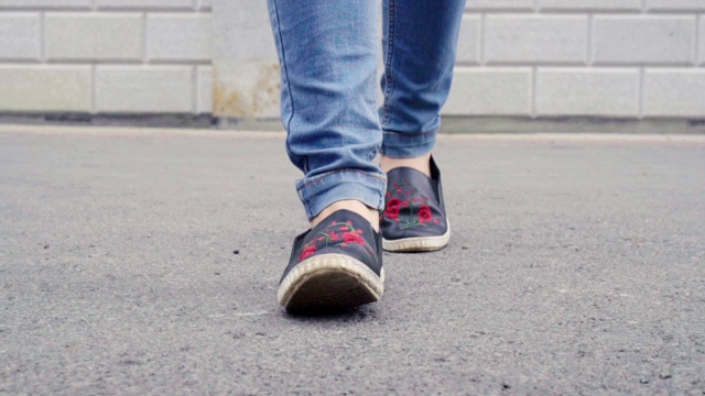 女人的脚在城市的人行道上行走的细节视频素材