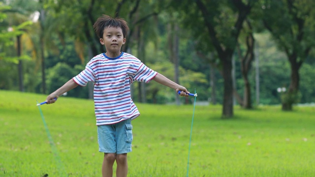 小男孩在草地上跳绳视频下载