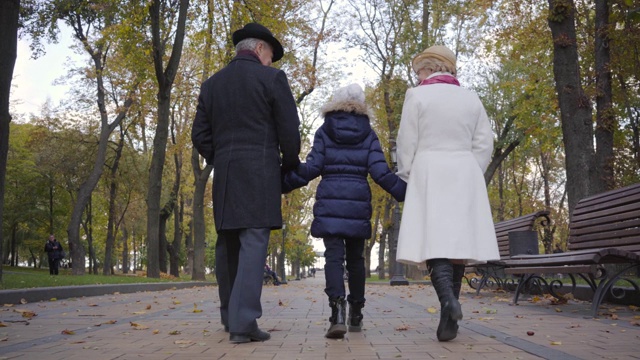 后视镜的一个白人老年夫妇走在一个女孩在白帽子沿着小巷视频下载