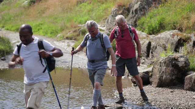 一群老年人踩着石头过河视频素材