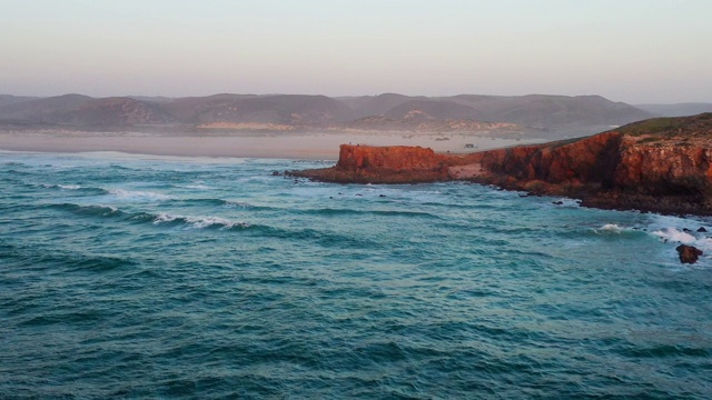 空中飞过海岸线，俯瞰通向大海的悬崖，日落时分的葡萄牙视频下载