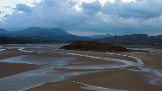 日落时分，北威尔士低潮时，低空飞过河口沙地上空视频下载