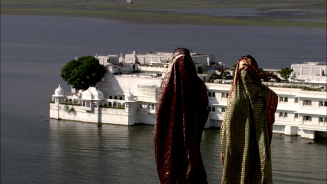 印度乌代普尔，两名穿着纱丽的妇女正在参观一座沿海宫殿。视频下载
