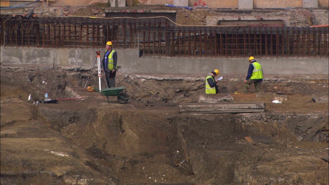 土地测量师在挖掘现场工作。视频素材