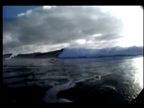 一个海浪击中了追踪一个冲浪者的摄像机，看起来像是要潜入水中。视频下载