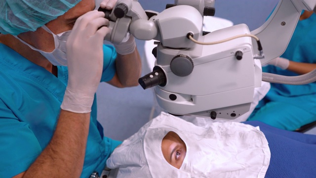 在光学手术中通过显微镜观察的外科医生视频素材