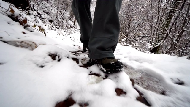 在一条被雪覆盖的危险狭窄的小路上徒步旅行的人视频素材