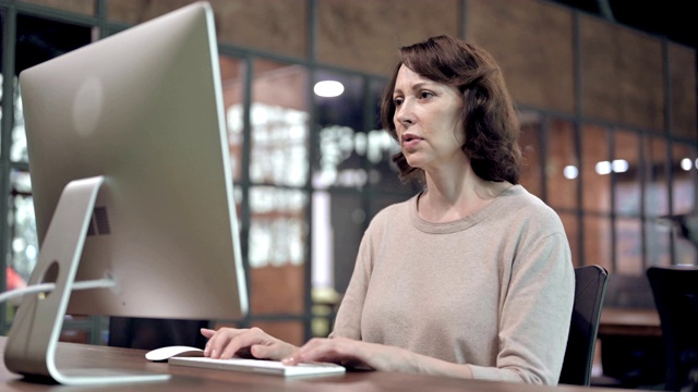 背疼，不舒服的老妇人在电脑上工作视频素材