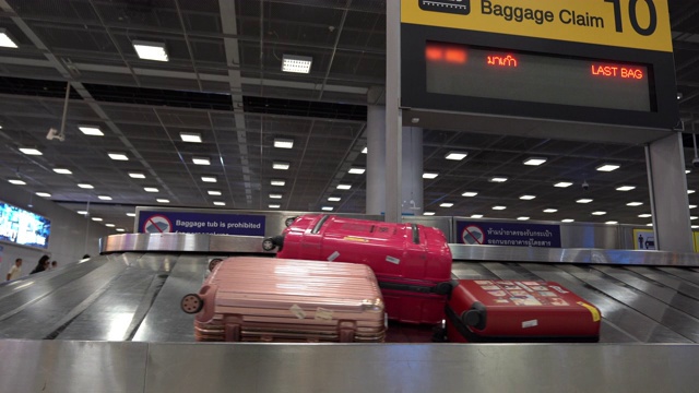 旅客的行李在机场的行李传送带上移动。视频素材