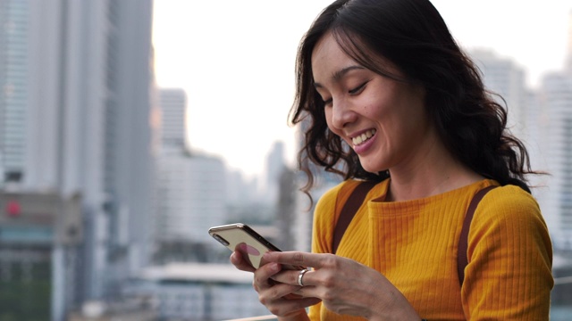 亚洲女性在城市使用智能手机视频素材