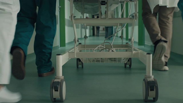 医生和护士推着病床上的病人走过医院走廊视频下载