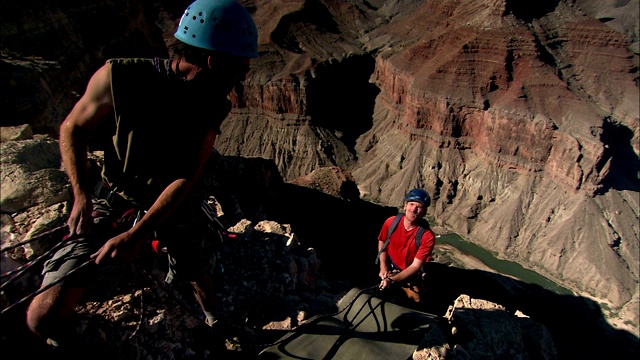 攀岩者沿沙漠悬崖攀爬而下。视频下载