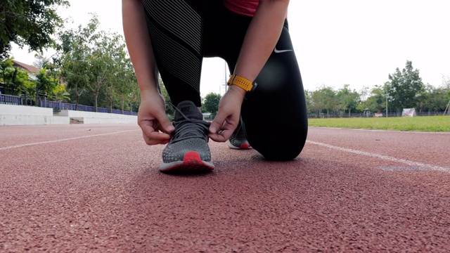 女跑步者系着她的运动鞋，慢动作视频素材