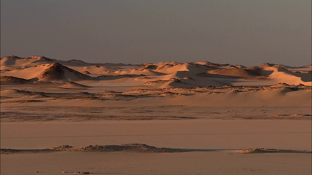 沙丘和岩层耸立在撒哈拉沙漠的Gilf Kebir地区。视频下载