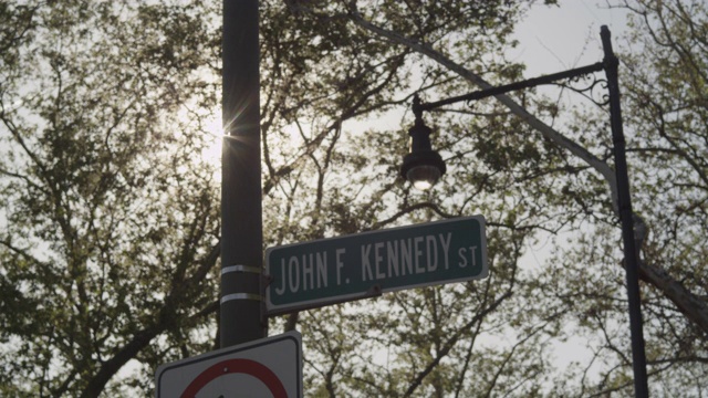 阳光照射在波士顿的一根柱子后面，柱子上写着“约翰·f·肯尼迪街”。视频下载