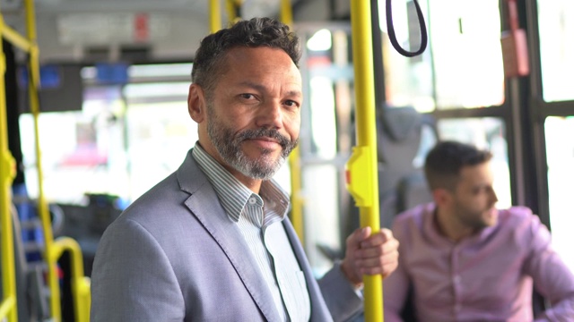 一个在公交车上看镜头的成熟男人的肖像视频素材