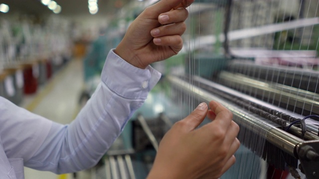 女人在工厂机器上检查橡胶螺纹的近距离观察视频下载