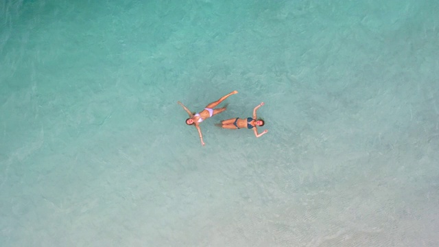 女朋友们在麦肯齐湖碧绿的海水和白色的硅石沙滩上玩耍。视频下载