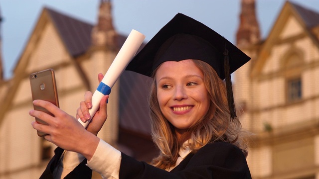 迷人的毕业女孩拿着毕业证书自拍毕业日视频下载