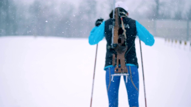雪景中一名女子滑雪运动员的后视图视频素材