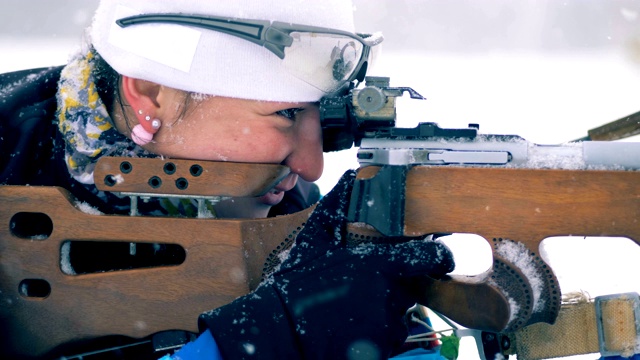 侧面的女运动员射击和重新装填步枪视频素材