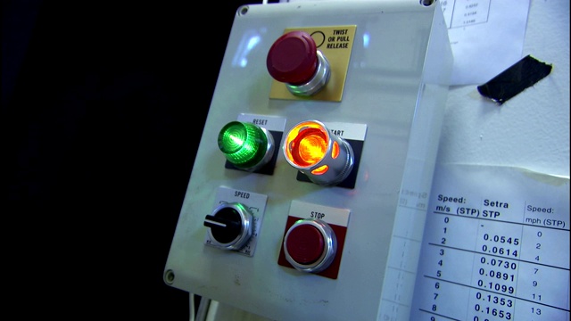 一名技术人员按下控制面板上发光的按钮。视频下载