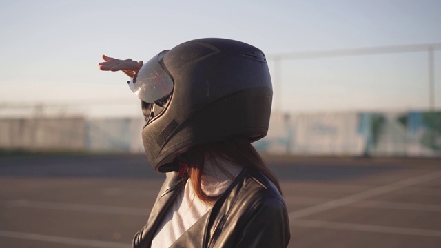 肖像美丽的年轻红发女子摩托车手坐在定制的摩托车在黑色摩托车头盔视频下载