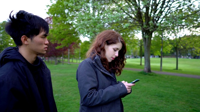 一对夫妇在公园里吵架-年轻的20岁亚洲男人和白人女人视频下载