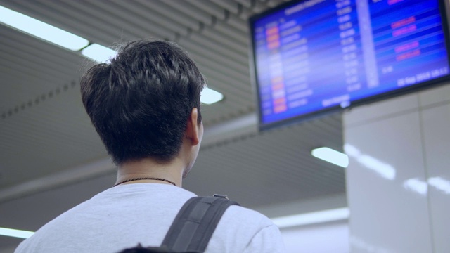 带着行李通过走廊过境，同时使用手机的男子旅客视频素材