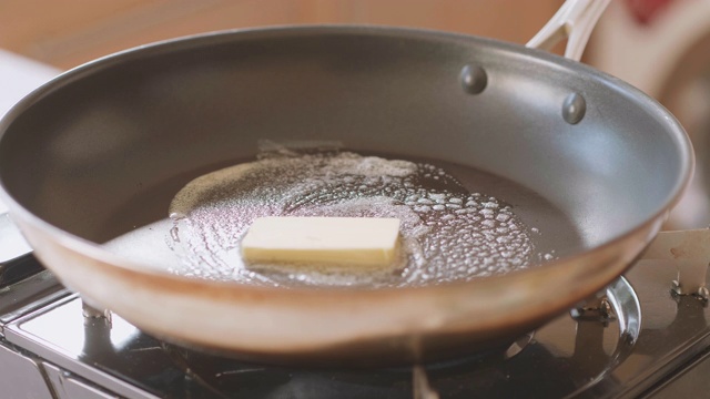 在煎锅上融化黄油块视频素材