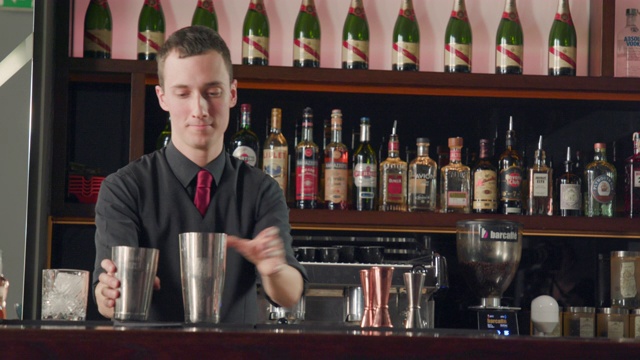 调酒师用鸡尾酒调酒杯滗出液体视频素材