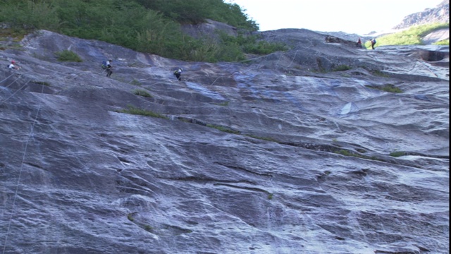 攀登者从光滑的悬崖上攀爬而下。视频素材