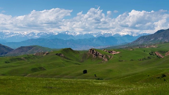 时光流逝的一个美丽的绿色山谷和山脉在吉尔吉斯斯坦的背景视频下载