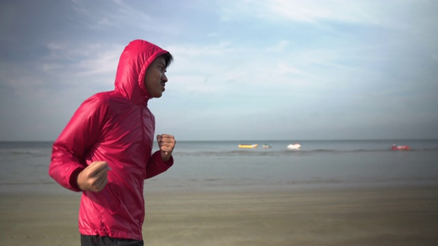 年轻的男性拳击手在海滩上奔跑视频下载