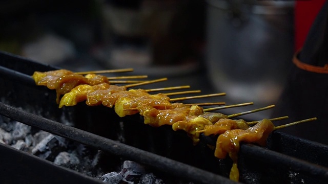 在热炭烤架上熏烤猪肉，泰国街头小吃。视频素材