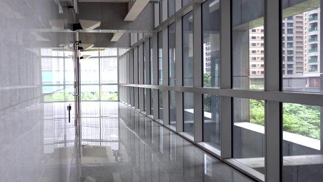 背景是走廊和透明的窗户。位置在现代建筑的公共场所区域。视频素材