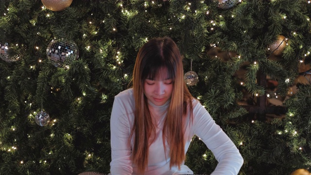 快乐的亚洲女人打开一个圣诞礼物魔术圣诞节日的概念。视频素材