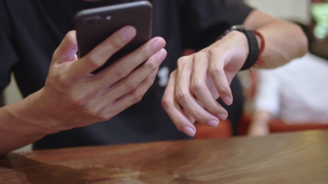 男子在餐厅使用智能手机时微笑视频素材