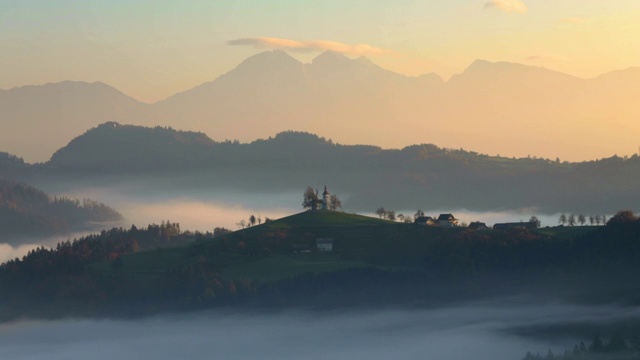 斯洛文尼亚山上教堂的空中日出图视频素材